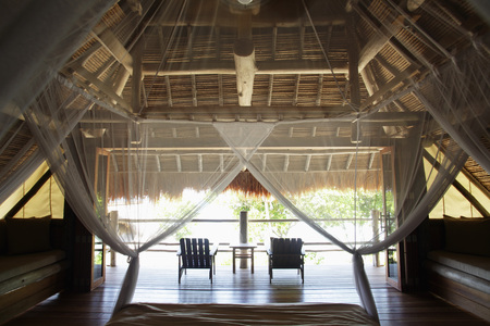 interior of thatched and wood house with mosquito nettingの写真素材