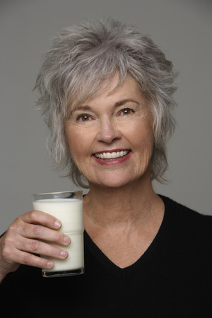 mature woman holding a glass of milkの写真素材