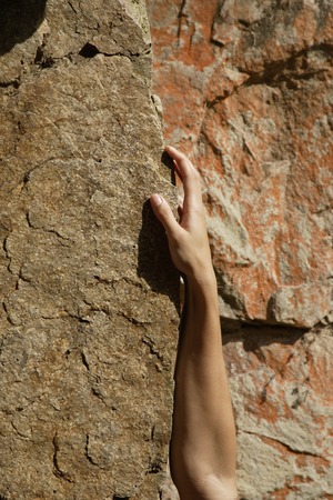 female hand on rockの写真素材