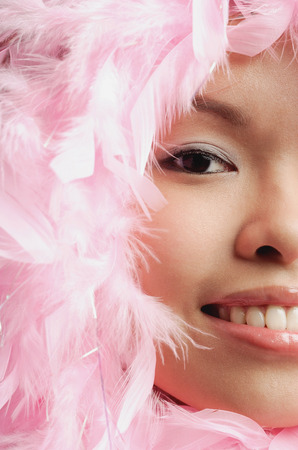 Woman with pink feathers around her face, cropped imageの写真素材