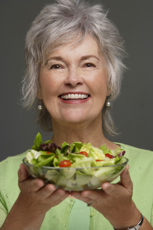Mature woman holding salad.の写真素材