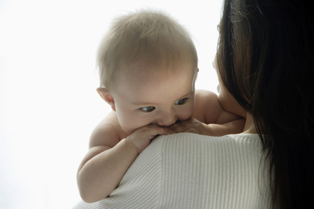 mother holding baby looking over her shoulder