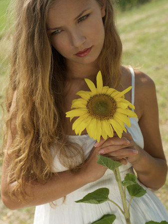 Young woman holding sunflowerの写真素材