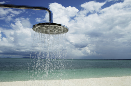 close up of outdoor shower with clouds and blue sky as backgroundの写真素材