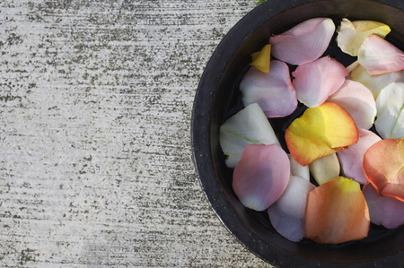 Petals floating in wooden bowlの写真素材