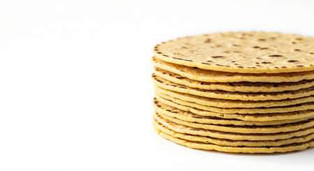 Minimalist flat lay of fresh, charred corn tortillas on white background.
