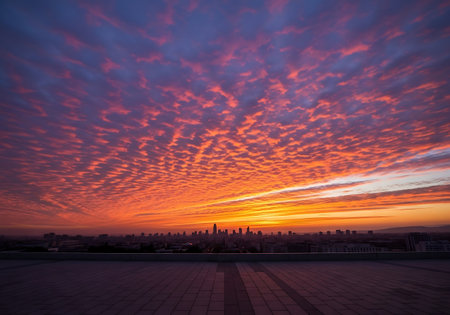 Extreme wide-angle sunrise over city silhouette with violet and orange clouds.の写真素材