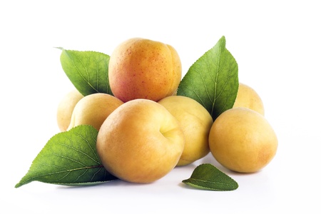 Mound of apricots with leafs on a white backgroundの写真素材
