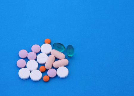 Different pills over blue background