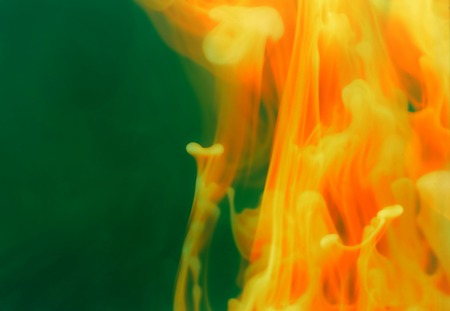Abstract flame-like shapes over green background with diffusion trailsの写真素材