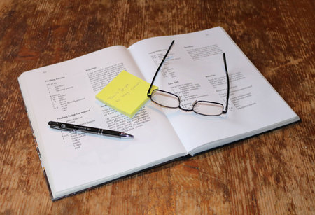 Reading a book and making notes on a sticky noteの写真素材