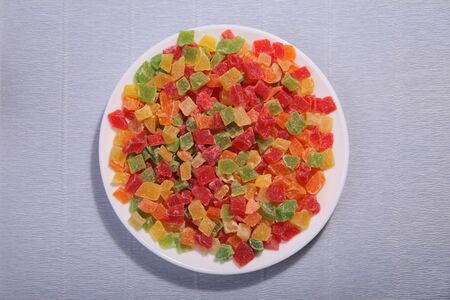 Pineapple slices on the plate. Four colours mixed. Candied fruit.の写真素材