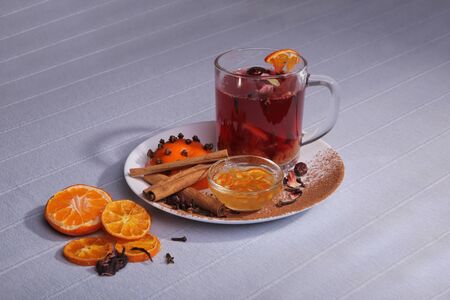 Still life. A cup of drink. Spices and fruits on a plate. Jam and cinnamon.の写真素材