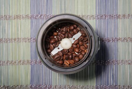 Coffee beans in a coffee grinder. Bamboo mat. Closeup.の写真素材