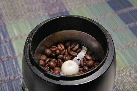 Coffee beans in a coffee grinder. Bamboo mat. Closeup.の写真素材
