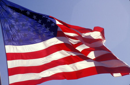 American flag flying in the skyの写真素材