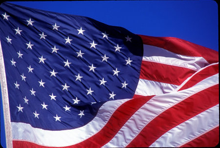American flag flying in the skyの写真素材