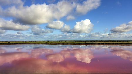 Clouds reflecting in pink lake aerial photo