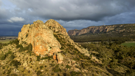 cliff in forest at sunset aerial photoの写真素材