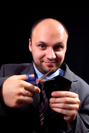man in a business suit scissors the tie, on a black background