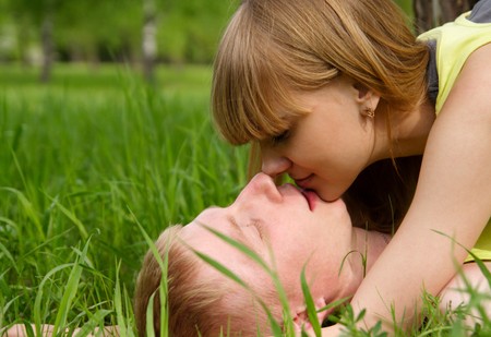 young beautiful woman and the man lay on a grassの写真素材