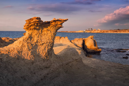 Beatiful Cyprus sunset on the desert empty rocky coast with strange fiqures at the Halk beach