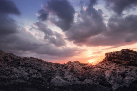 Sundown with clouds and rocksの写真素材