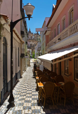 Narrow street with cafe in Alcobasa Portugalの写真素材