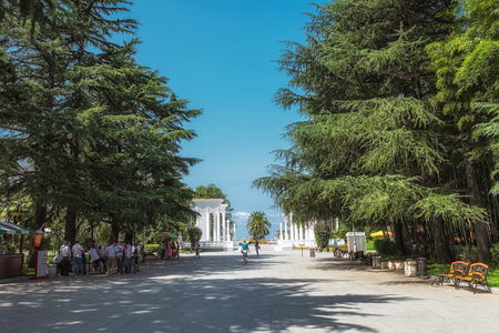 Batumi. Georgia - September 2, 2014. Seafront with trees, people and white column constructions.のeditorial素材