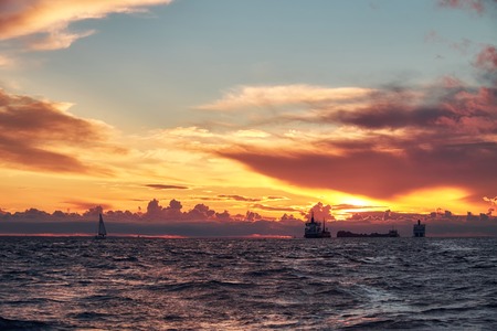Sea sunset with ships and boat on horizon