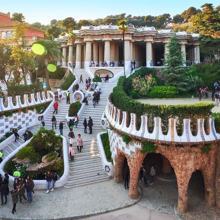 March 2017, Barcelona, Spain - View to the main attaractions of the park Guel full of tourists. Hundred columns hypostyle room, central terrace with serpentine bench, stairs, lizard statue.のeditorial素材