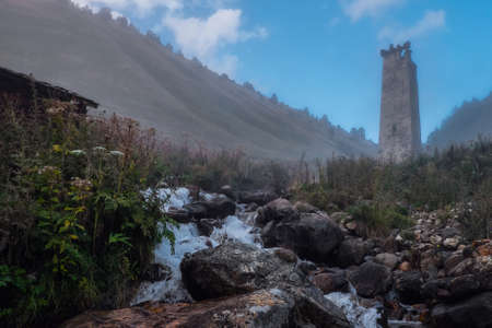 Mountain landscape with ruined svan tower, spring and fog, Svaneti Georgiaの写真素材
