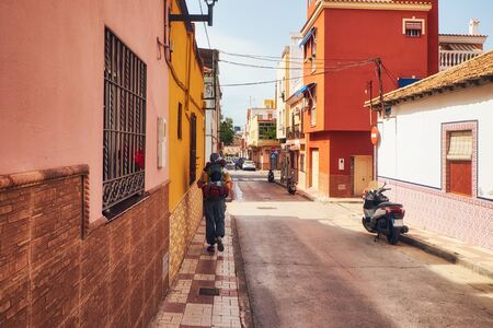 Sunny street on the outskirts of Malaga and tourist walking away with backpack. Andalusia. Spainの写真素材