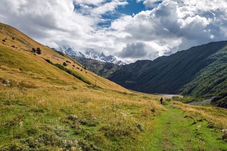 Landscape with green meadow in mountains on a cloudy but sunny day Svaneti Georgiaの写真素材