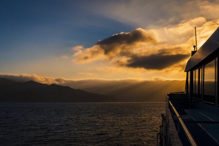 watching the sunset gorgeous sunlight over the clouds on the boatの写真素材
