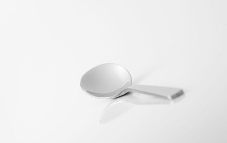 Steel teaspoon is on reflective surface, nothing elseの写真素材