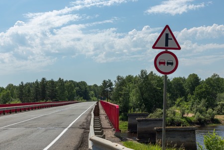 two signs on the road before the bridgeの写真素材