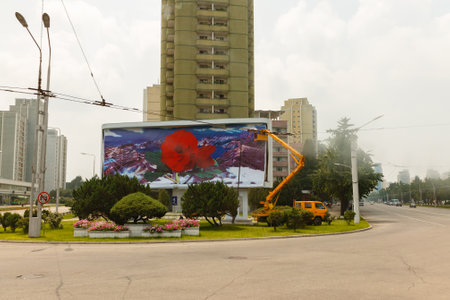 Pyongyang, North Korea - July 29, 2014: North Korean workers are installing a poster on Pyongyang...