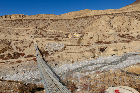 suspension bridge across mountain river, Himalayas, Nepalの写真素材