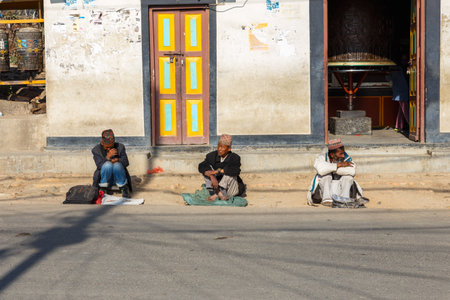 Kathmandu, Nepal - November 13, 2016: Three men sit on the road at the Swayambhunath temple in...