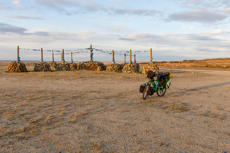 Tourist bicycle and Mongolian Ovoo, Ceremonial Rock Pile on Mountain Top, Mongolia.の写真素材