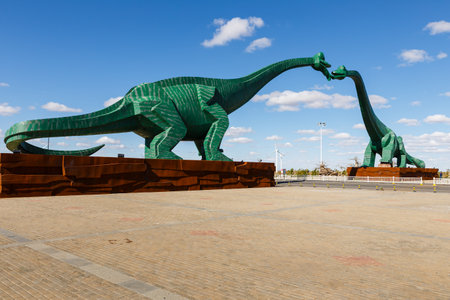 Erenhot, Inner Mongolia, China - September 23, 2018: Two green kissing dinosaurs. Statues of two dinosaurs located on both sides of the road near the city.のeditorial素材