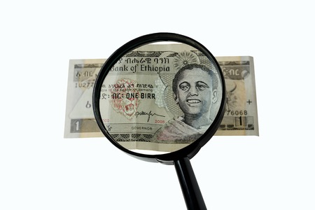 one Ethiopian birr bill and magnifying glass isolated on white background, obverse front sideの写真素材
