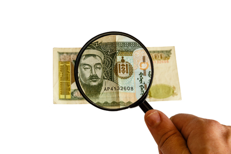 five hundred Mongolian tugriks bill and magnifying glass in hand isolated on white background, obverse front sideの写真素材