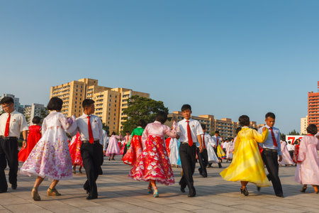 Pyongyang, North Korea - July 27, 2014: Mass dance in honor of victory day in the war at the Workers Party Foundation Monument. Korean people in traditional dresses dance in the street.のeditorial素材