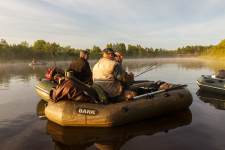 Tuzha, Russia - June 12, 2019: fishermen catch fish on a rubber boat on a forest river. Pizhma River in the morning.のeditorial素材