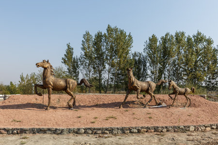 Katta Turk, Uzbekistan - October 18, 2019: A statue of running horses on the side of the road in the Dangara district of the Ferghana region.のeditorial素材