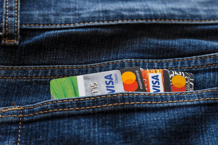Moscow, Russia - May 3, 2020: Plastic cards Visa and Mastercard in the back pocket of jeans.のeditorial素材