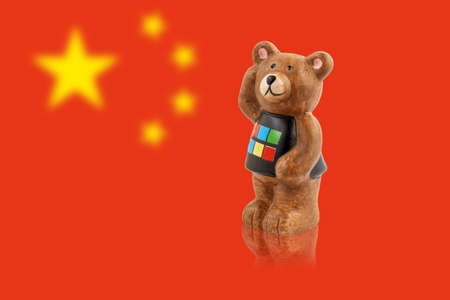 A figurine of a bear against the background of the flag of China.の写真素材