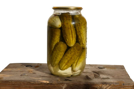 Canned cucumbers. Glass jar with cucumbers on a wooden board on a white background.の写真素材
